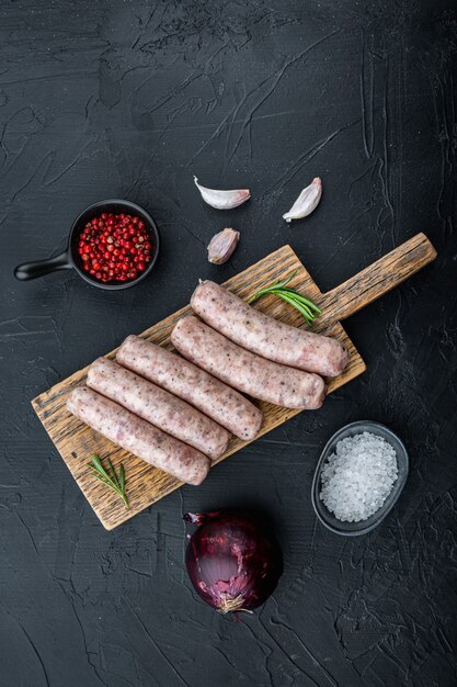 Raw sausages on dark background