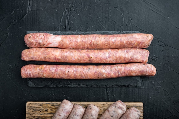 Raw sausages on dark background