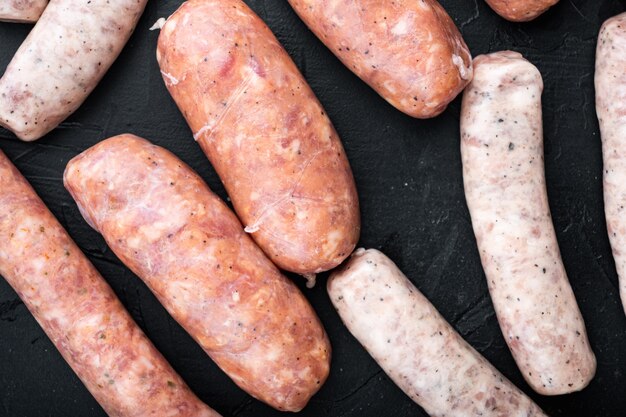 Raw sausages on dark background