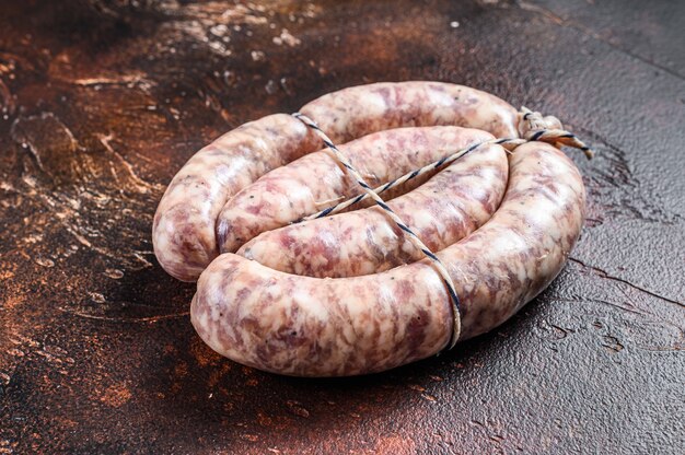 Raw sausages from pork and beef meat on the wooden board