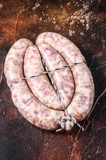 Raw sausages from pork and beef meat on the wooden board