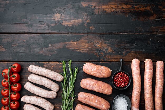 Raw sausages on old dark wooden background