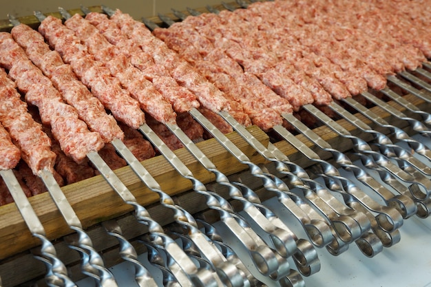 Raw sausages strung on skewers before grilling