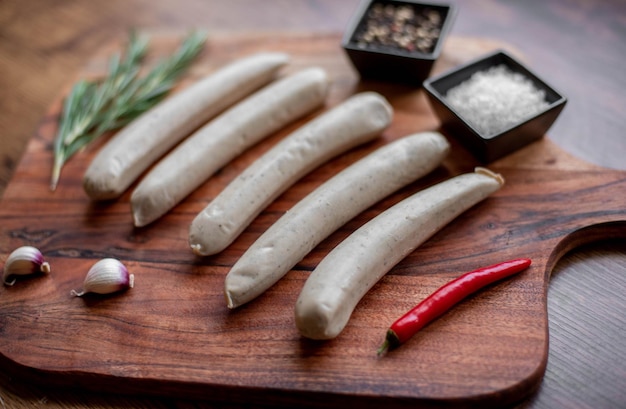 raw sausages with spices on a rustic background