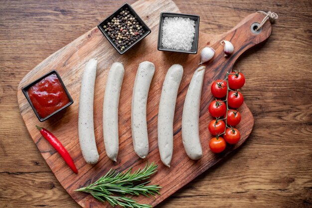 raw sausages with spices on a rustic background