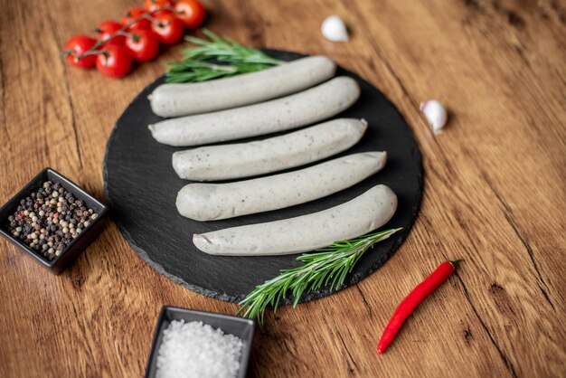 raw sausages with spices on a rustic background