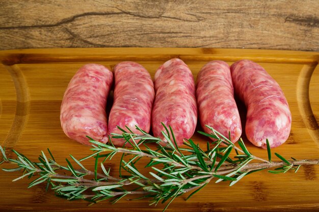 Raw sausages on the wooden board