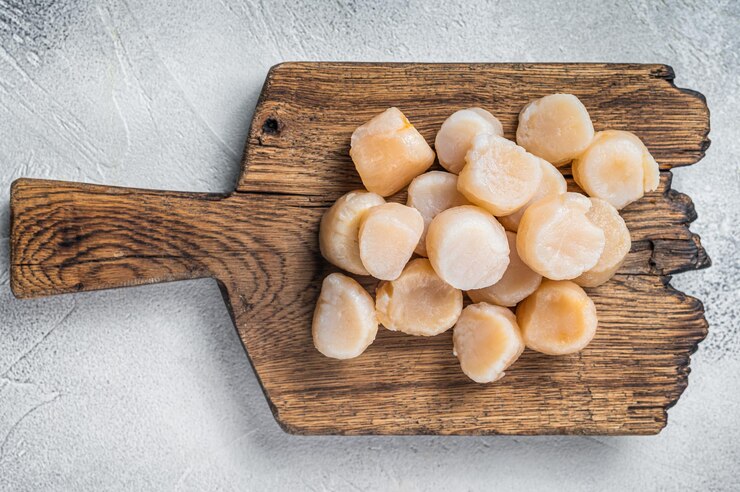 Photo raw scallops on a wooden board white background top view copy space
