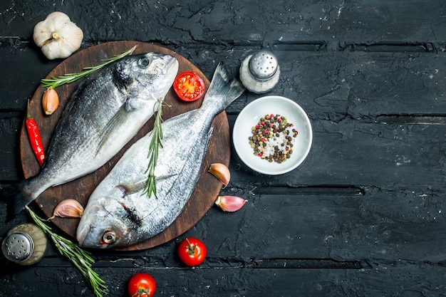 Raw sea fish dorado with spices and vegetables