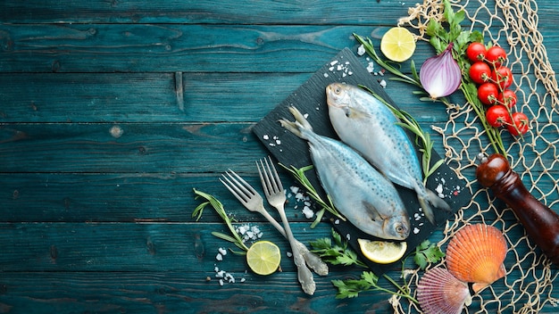 レモン塩とローズマリーと生の海の魚黒の背景に上面図無料コピースペース