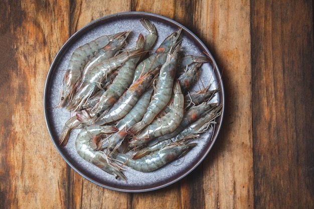 Raw seafood Fresh shrimps prawns on gray plate Wooden backround