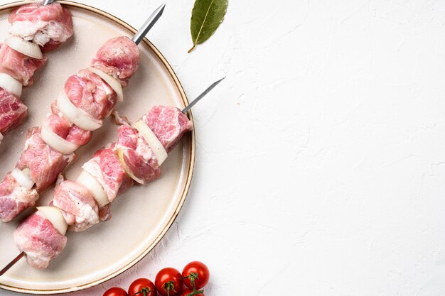 Raw shish kebab. Barbecue Meat Spices and Herbs set, top view flat lay, with copy space for text, on white stone table background