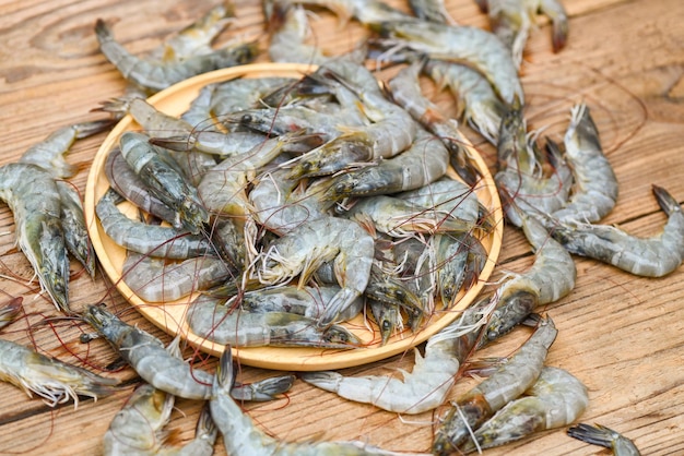 Raw shrimp on wooden plate and shrimps background for cooking close up fresh shrimps or prawns seafood shelfish