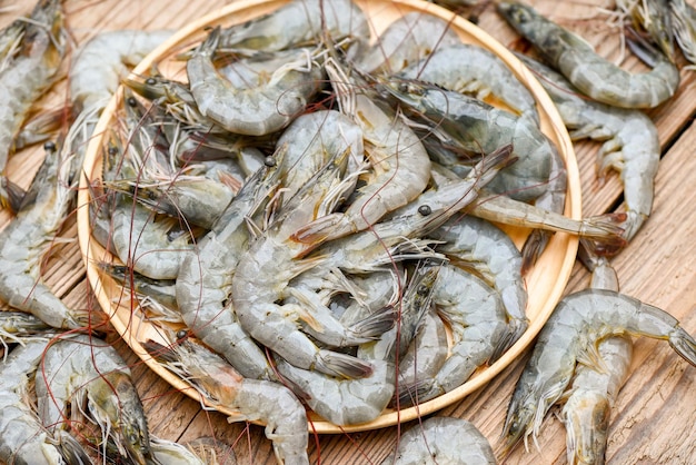 Raw shrimp on wooden plate and wooden board background for cooking close up fresh shrimps or prawns Seafood shelfish