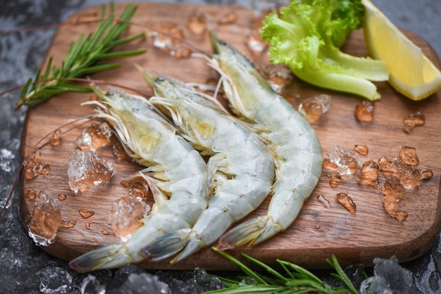 Raw shrimps with ice on cutting board