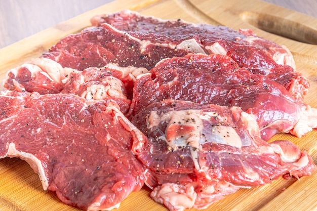 Raw sirloin steak cut into steaks on a wooden board on a wooden table