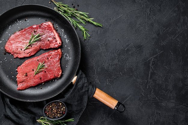 Raw Sirloin steak in a frying pan. Beef meat. Top view. Copyspace background