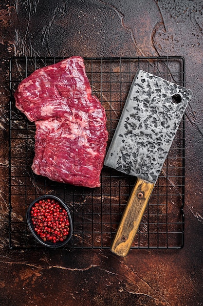 Photo raw skirt beef steak on meat cleaver black background top view