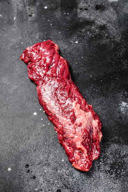 Raw skirt, machete steak. Black surface. Top view