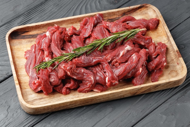 Raw sliced beef meat on wooden board