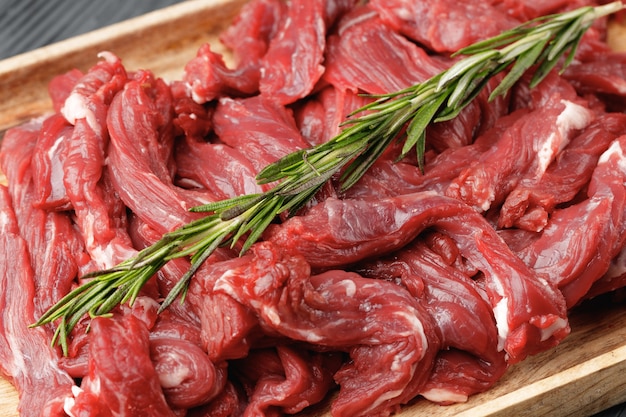 Raw sliced beef meat on wooden board