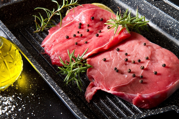 Raw sliced beef on plate pot on black background