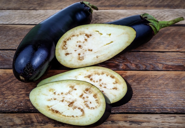 Raw sliced eggplant on wooden background