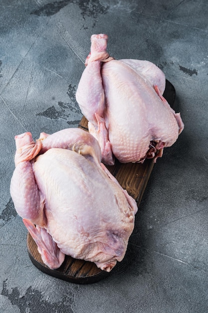 Raw small young whole chicken, on gray background with copy space for text