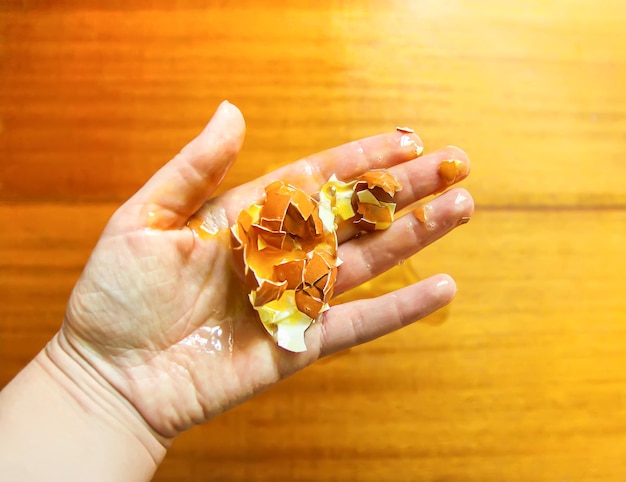 Raw smashed egg in a hand.