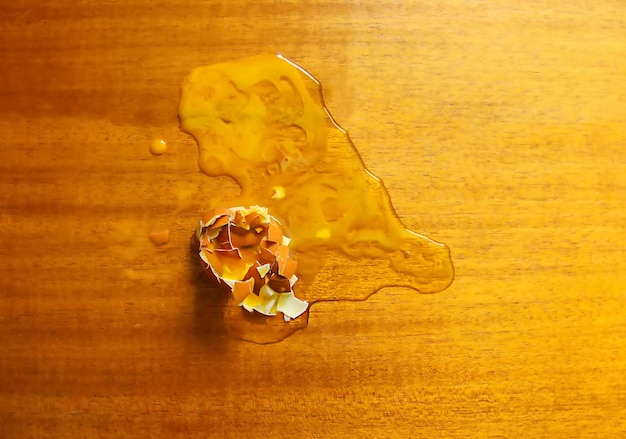 Raw smashed egg on wooden table