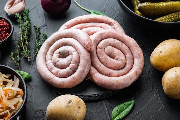 Photo raw snail sausage in traditional spiral set, on black background