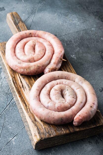 Raw snail sausage in traditional spiral set, on gray background