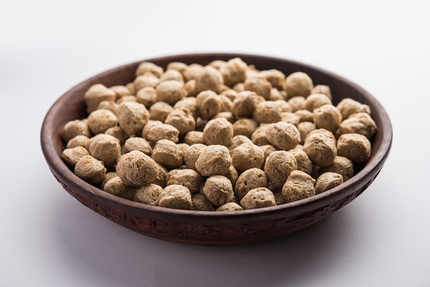 Raw Soya Chunks, Soy Meat for vegans isolated on colourful background in a bowl or in heap form