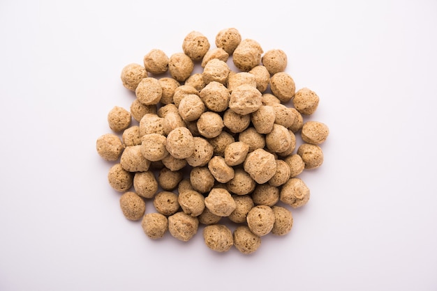Raw Soya Chunks Soy Meat for vegans isolated on wooden table in a bowl or in heap form