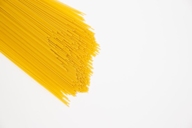 Macro italiana dell'alimento degli spaghetti crudi su fondo bianco