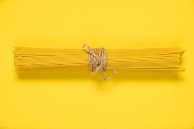 Photo raw spaghetti italian food macro on yellow background