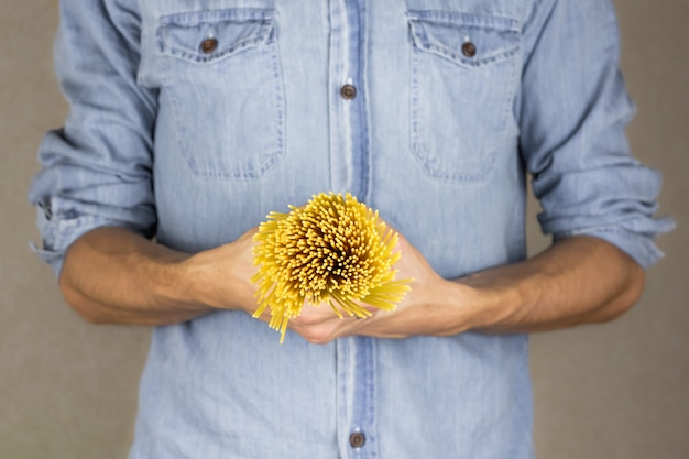 Raw spaghetti in male hands