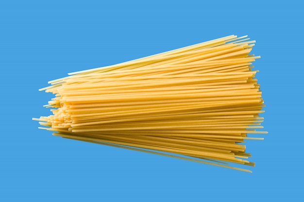 Pasta cruda degli spaghetti su fondo blu