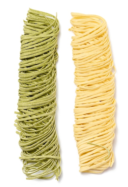 Raw spinach and egg noodles on white background top view