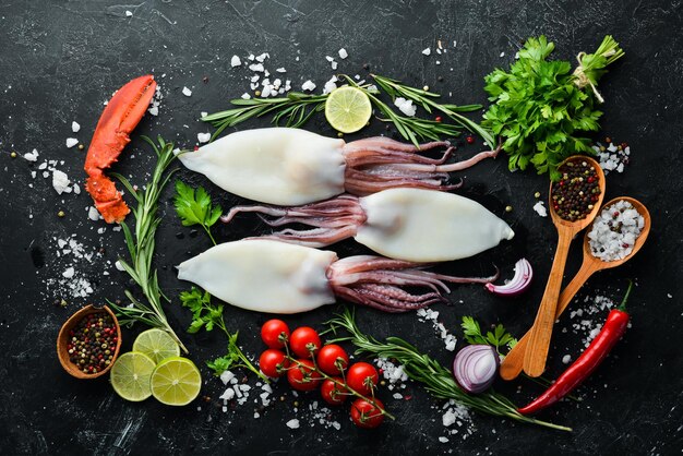 Raw squid with spices Seafood on a black stone background Top view Free copy space