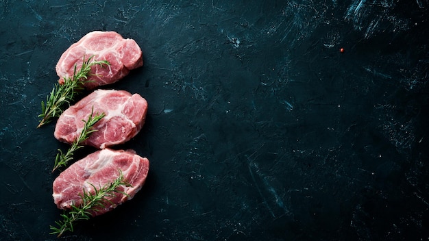 Raw steak Meat with spices and herbs On a black stone background Top view Free copy space