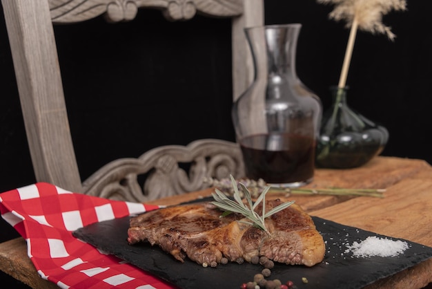 Raw steak on pizarra dish isolated on black background.