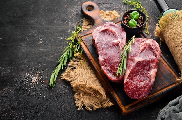 Raw Steak Ribeye Op een zwarte stenen tafel Bovenaanzicht Vrije ruimte voor uw tekst