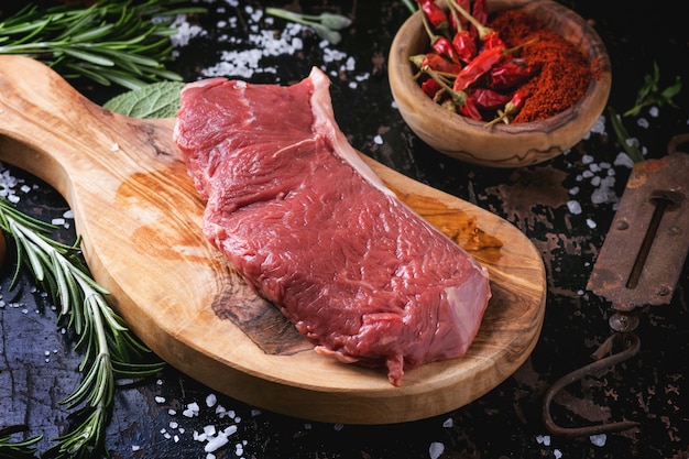 Raw steak with herbs and pepper