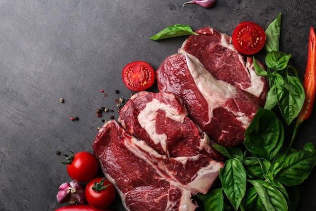 Raw steak with spices on table