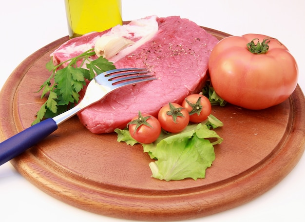 raw steak on wooden board