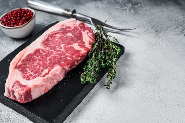 Raw striploin or new york strip steak on a marble board