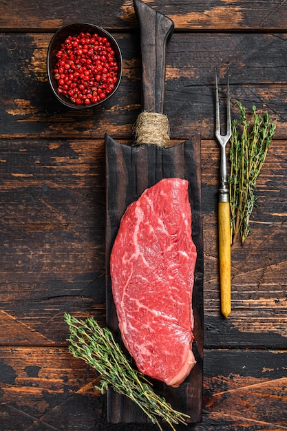Raw Striploin steak on a cutting board, marbled beef