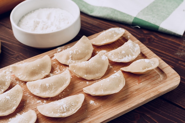 Gnocchi russi ripieni crudi sul bordo di legno