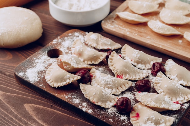 Raw stuffed russian dumplings on wooden cutting board